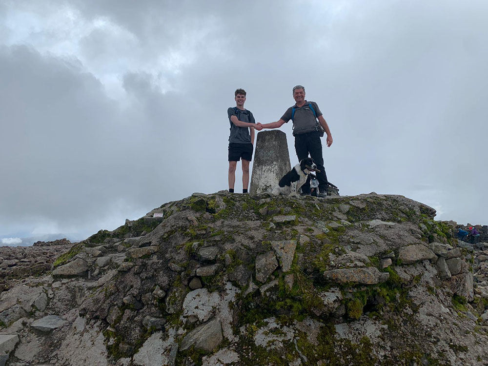 Mick, Dominic his son and Alfie by the trig point on Ben Nevis