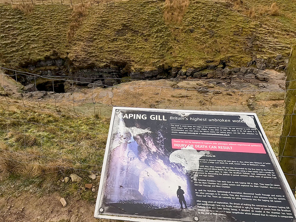 Information board about Gaping Gill, with Gaping Gill below
