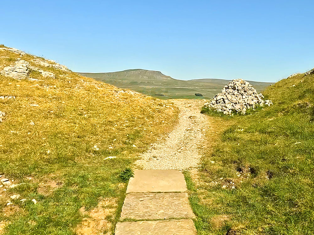 Another flagged section on the Yorkshire Three Peaks path with Pen-y-ghent just visible on the horizon