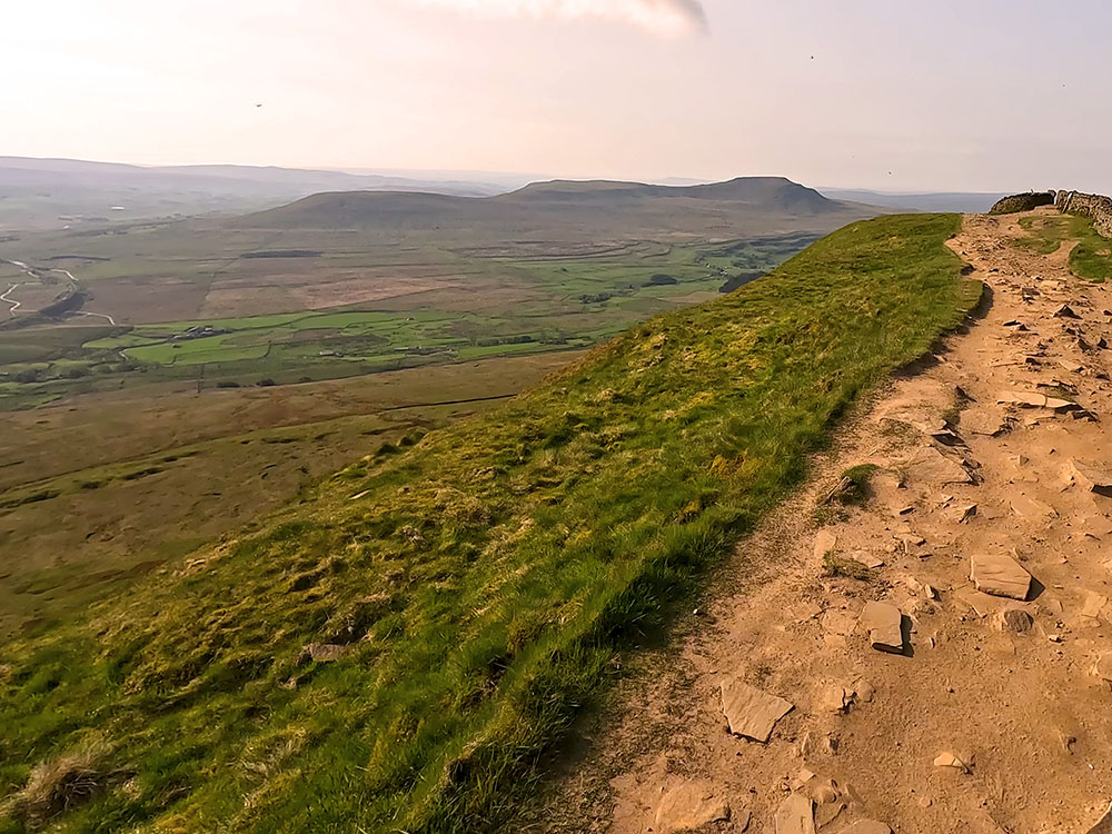 Path by the wall heading towards Whernside's summit with Ingleborough ahead