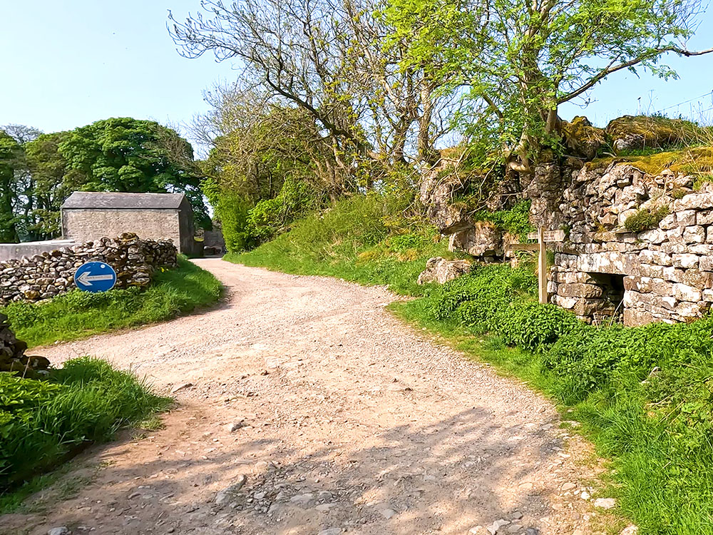 The left turn down the road following the Yorkshire 3 Peaks footpath sign
